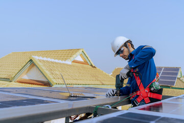 A technician use a the Electric drill installing the solar panels at roof top