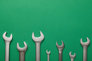 Set of metal wrenches on color background