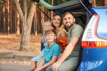 Fototapeta na wymiar Happy family sitting in car trunk outdoors