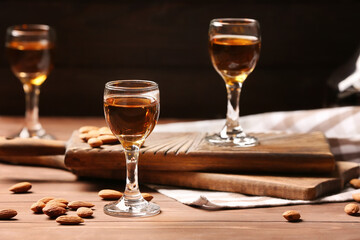 Composition with glasses of almond liquor and nuts on dark background