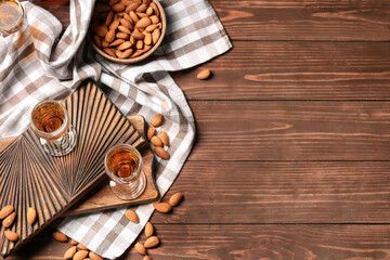 Composition with glasses of almond liquor and nuts on wooden background