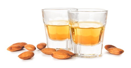 Glasses of almond liquor and nuts on white background