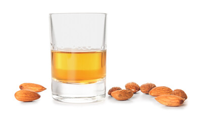 Glass of almond liquor and nuts on white background