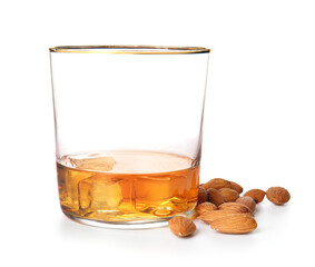 Glass of almond liquor and nuts on white background