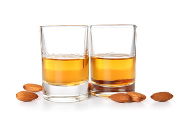 Glasses of almond liquor and nuts on white background