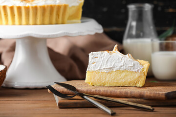 Board with piece of tasty coconut pie on wooden background