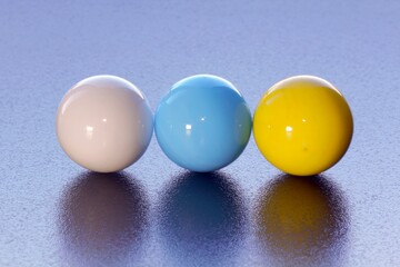 White, Blue and Yellow marbles on textured surface - stock photo