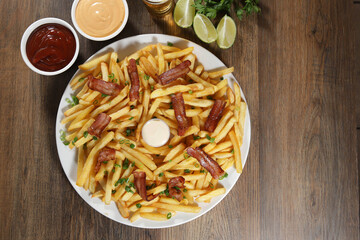 Portion of french fries with bacon. Lettuce, potato, green onion, tomato, ketchup and mayonnaise