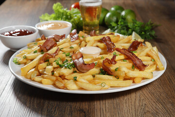 Portion of french fries with bacon. Lettuce, potato, green onion, tomato, ketchup and mayonnaise