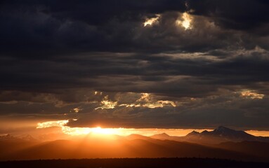 dramatic sunset over  long's peak and the front range of the colorado rocky mountains as seen from broomfield, colorado
