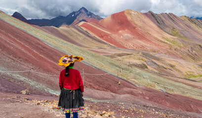 Quechua woman with the painted hills of the Rainbow Mountain (Vinicunca), Cusco Province, Peru