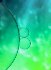 Closeup oil and water droplets on green  light effect colour background.