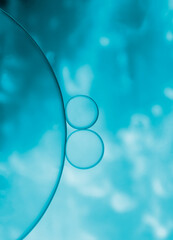 Beautiful abstract oil and water droplets bubbles on blue colour with light effect background.