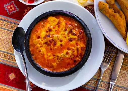 Baked shrimps with tomatoes, mushrooms and cheese in crock, tirkish dish Karides guvec