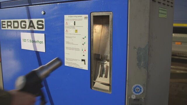 The hand of a young girl operating CNG gas pump