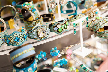 Handmade bracelets with precious stones on the showcase of a jewelry store