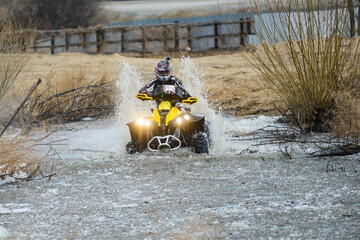 The man on the ATV crosses a stream. Tourist walks on a cross-country terrain.