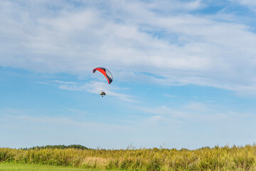Fototapeta na wymiar Moto-paraglider on green grass with blue sky.