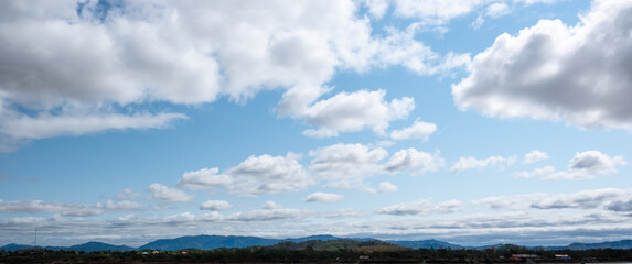 The white clouds have a strange shape and moutain.The sky and the open space have mountains below.Clouds floating above the mountains.