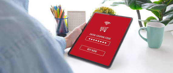 Hand holding discount coupon code on laptop screen to get the shopping on line cyber monday...