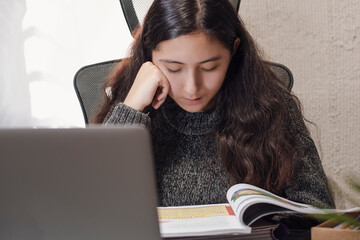 Hispanic Latino teen girl woman takes distance classes online with her teacher sheltering at home from the covid-19 pandemic