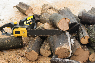 Electric saw on sawn logs in the open air.
