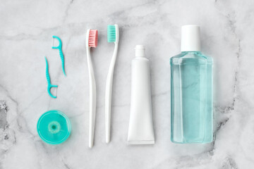 Set of pink and turquoise blue toothbrushes, toothpaste and other tools on marble background. Dental and health care concept. Top view, flat lay. - 417509004