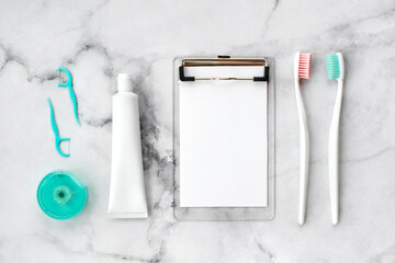 Set of pink and turquoise blue toothbrushes, toothpaste and other tools on marble background. Dental and health care concept. Top view, flat lay. Free copy space. - 417509010