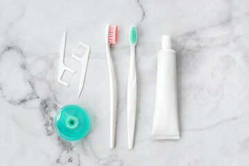 Set of pink and turquoise blue toothbrushes, toothpaste and other tools on marble background. Dental and health care concept. Top view, flat lay. - 417509014