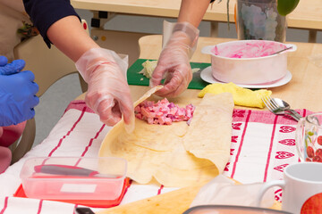 cooking shawarma in a school class at a labor lesson. vegetables in pita bread. parts of hands...