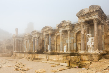 Fototapeta premium View of ruins of antique Nymphaeum of Sagalassos ancient city, Turkey, in foggy winter day