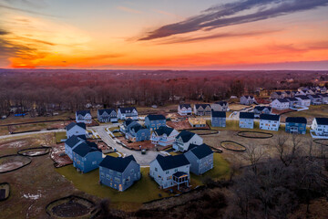 Curving suburban neighborhood dead end street with newly constructed single family homes in an...