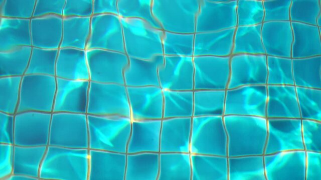 4k video of Water surface texture and blue water in the swimming pool with light reflections