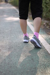 Fototapeta na wymiar Feet of an athlete running on a park.
