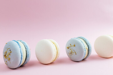 White and blue macaroons on the table, macaroons on pink background