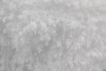 White snow for the backdrop. Frozen state of water in the form of snowflakes. Loose snow. Close-up. Selective focus.