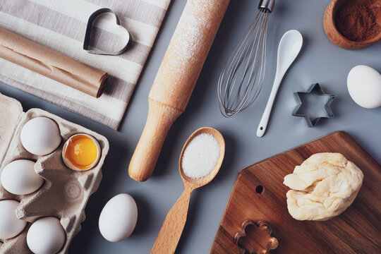 Flat layout composition, baking ingredients and kitchen utensils on a gray background. Culinary trendy background. The concept of making homemade desserts for the holiday