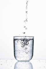 Glass cylindrical vessel without a handle, serving for drinking, pouring mineral water, on a white background