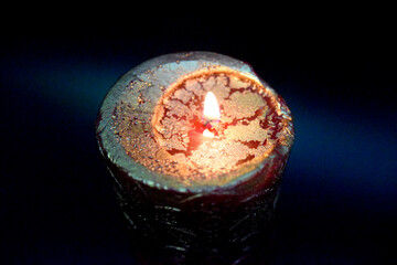 top of the birning candle with golden layer ob the red wax