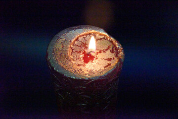 top of the birning candle with golden layer ob the red wax