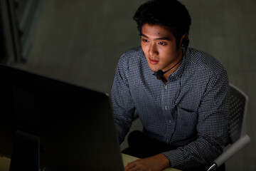 Top view shoot smiling confident asian man call center support wearing headphone look at camera and show thumb finger feeling happy with his working job