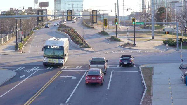 Early morning hustle and bustle of the morning commute to work. Wide Shot of cars and bus driving through a stoplight in the sunshine of downtown Atlanta, Georgia USA. Shot in 4k pro res 422