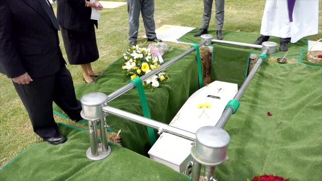 closeup shot of a funeral casket in a hearse or chapel or burial at cemetery