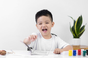 Happy little Asian kid at the table draw with watercolor Learning and education of kid.