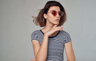 Fototapeta premium romantic woman in striped t-shirt portrait on gray background and fashionable glasses on face