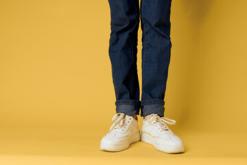 feet jeans fashion shoes white sneakers yellow background