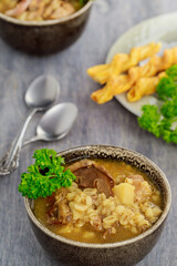 Mushroom soup with pearl barley and bread stick.