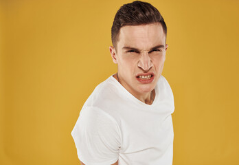 Side view of a man in a white T-shirt on a yellow background