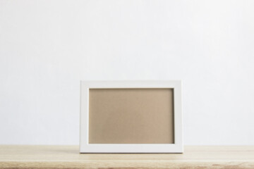 Photo frame with white background on wooden table