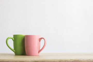 Colorful cups with white background on wooden table